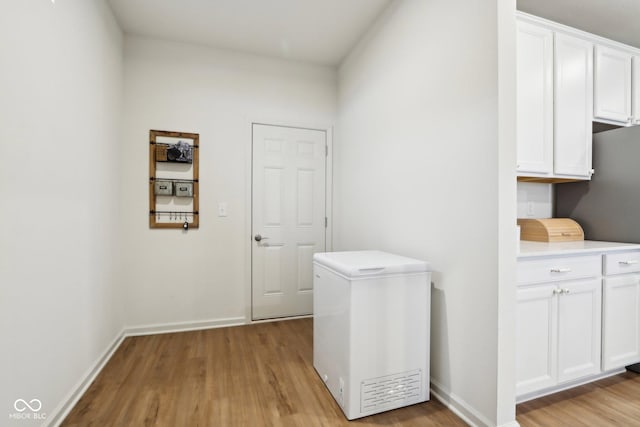 washroom featuring light hardwood / wood-style floors and cabinets