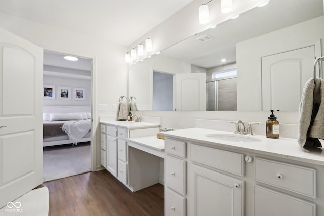 bathroom with hardwood / wood-style flooring, vanity, and a shower with door