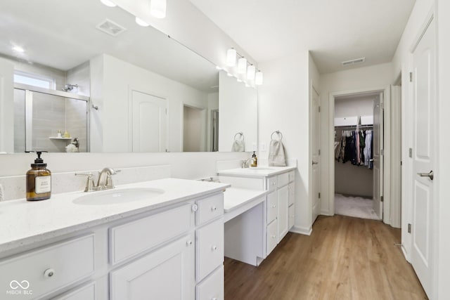 bathroom featuring walk in shower, vanity, and hardwood / wood-style flooring