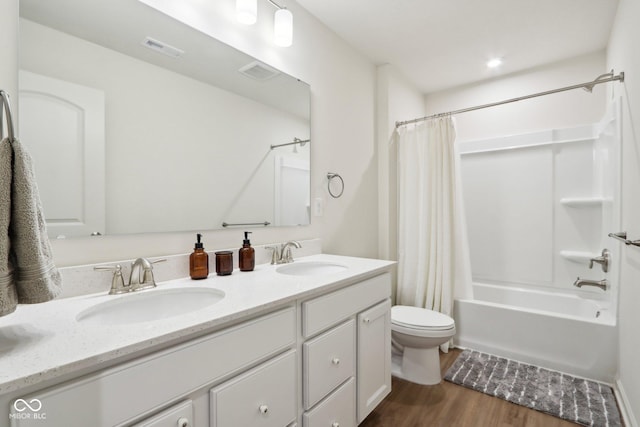 full bathroom featuring vanity, hardwood / wood-style floors, toilet, and shower / bath combo