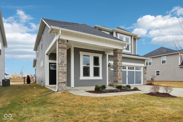 view of front of house with a garage, central air condition unit, and a front lawn