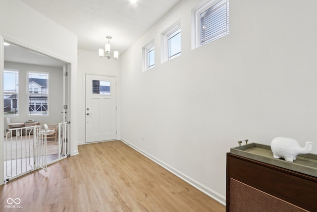 entrance foyer featuring an inviting chandelier, plenty of natural light, and light wood-type flooring