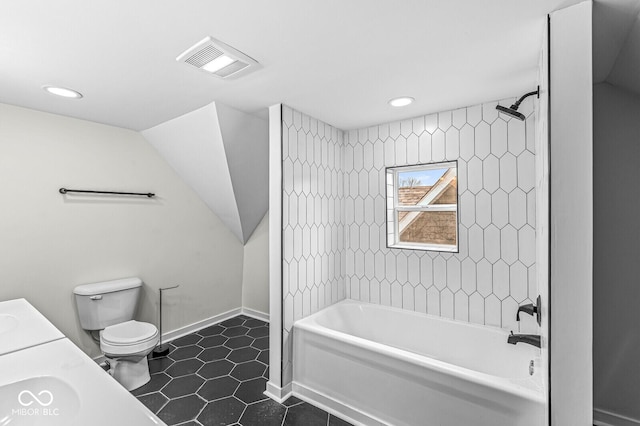 full bathroom with tile patterned flooring, vanity, tiled shower / bath combo, and toilet