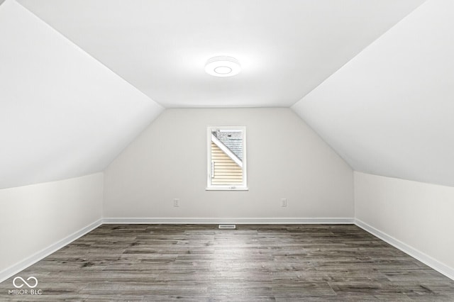 bonus room with dark hardwood / wood-style floors and vaulted ceiling