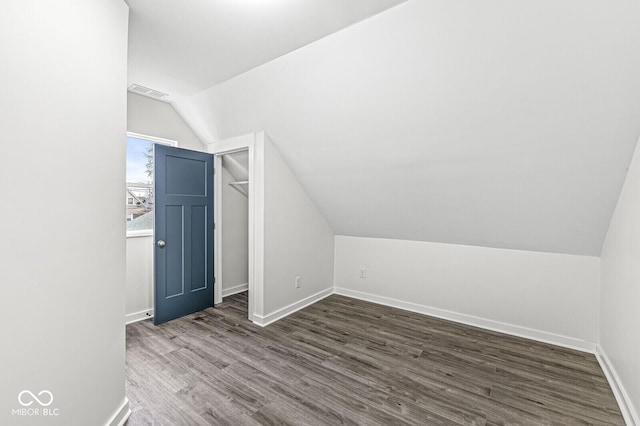 additional living space with dark hardwood / wood-style floors and vaulted ceiling