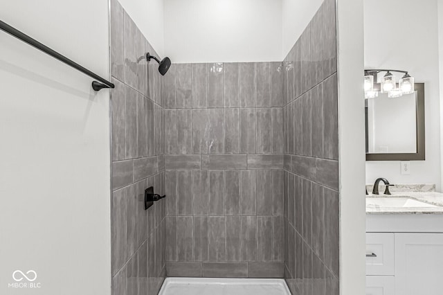 bathroom with vanity and a tile shower