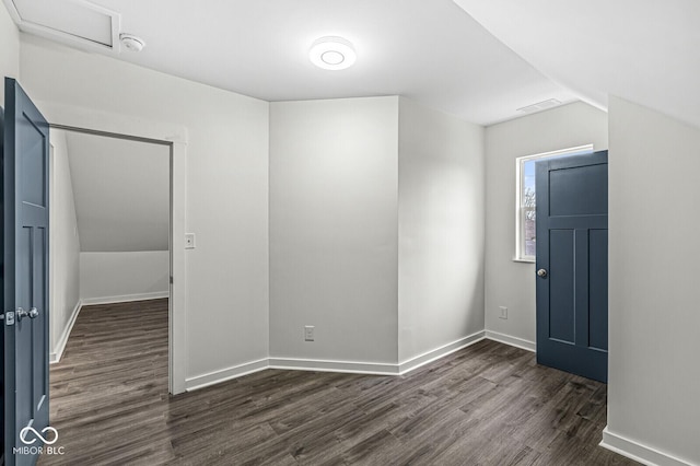 spare room with lofted ceiling and dark hardwood / wood-style floors