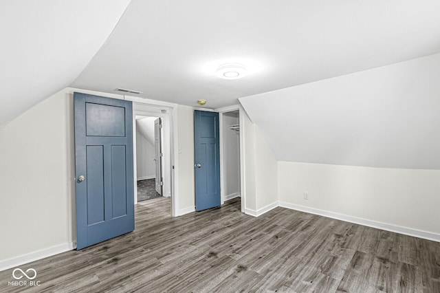 bonus room with hardwood / wood-style flooring and vaulted ceiling