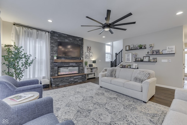 living room with ceiling fan, wood-type flooring, and a fireplace