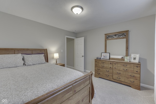 bedroom featuring light carpet and a textured ceiling