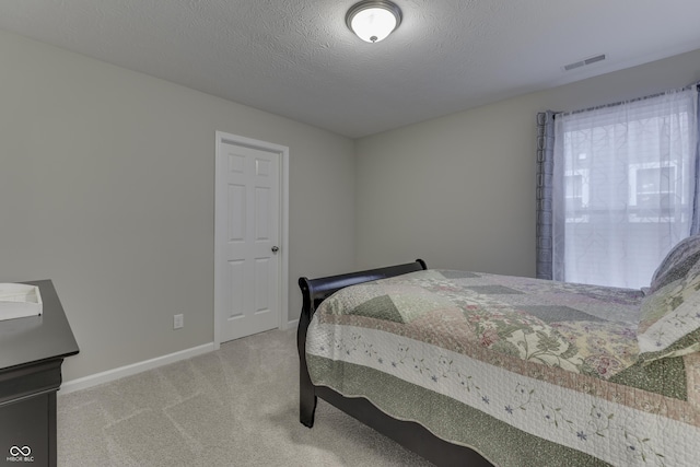 bedroom with carpet floors and a textured ceiling