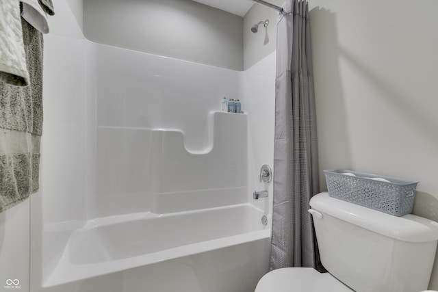 bathroom with toilet and shower / bath combo with shower curtain