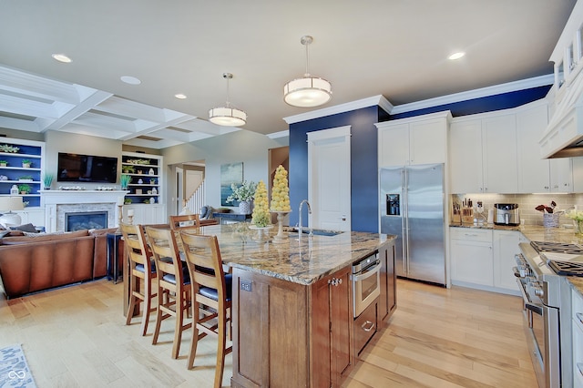 14445 Gainesway Cir, Fishers, IN 46040 - kitchen with appliances with stainless steel finishes, open floor plan, light wood finished floors, ornamental molding, and light stone counters