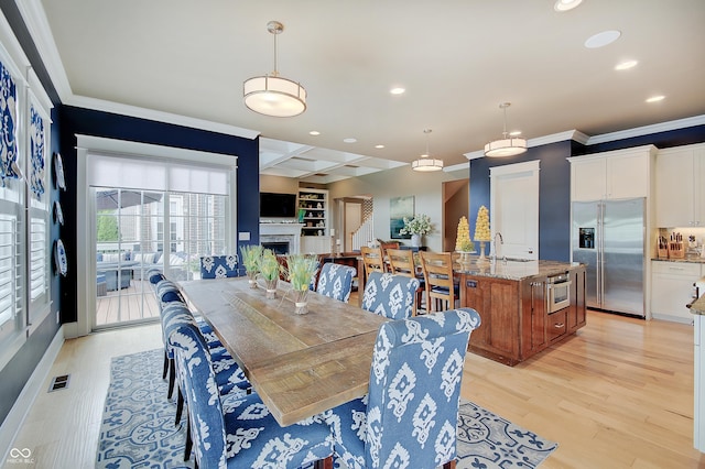 14445 Gainesway Cir, Fishers, IN 46040 - dining space with crown molding, recessed lighting, light wood finished floors, a fireplace, and beamed ceiling