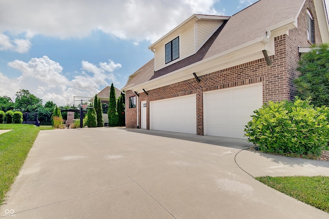 14445 Gainesway Cir, Fishers, IN 46040 - view of side of home featuring brick siding, concrete driveway, and a garage