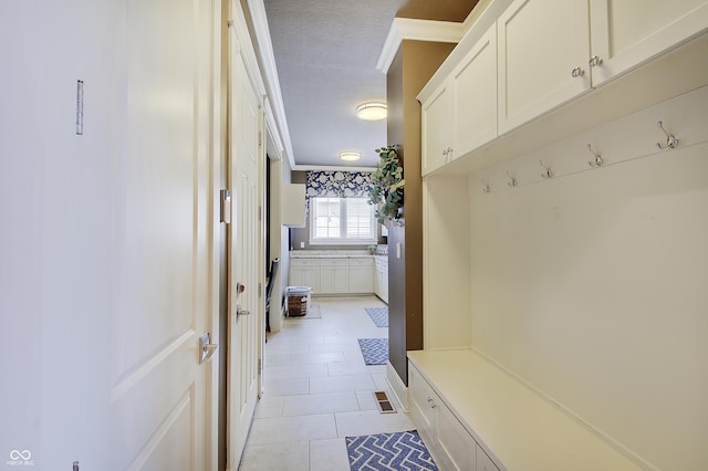 14445 Gainesway Cir, Fishers, IN 46040 - mudroom featuring light tile patterned flooring, a textured ceiling, and crown molding