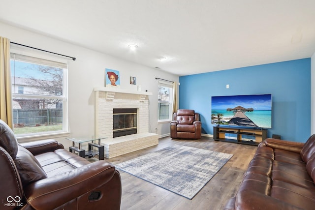 living room featuring hardwood / wood-style flooring and a brick fireplace