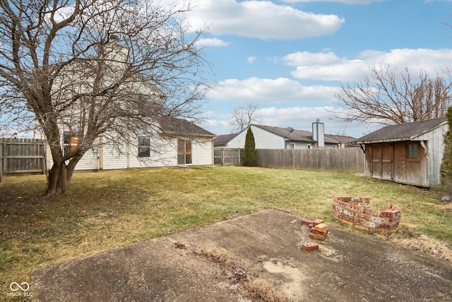 view of yard with a storage shed and a fire pit