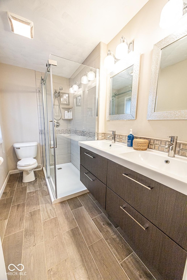 bathroom with walk in shower, vanity, and toilet