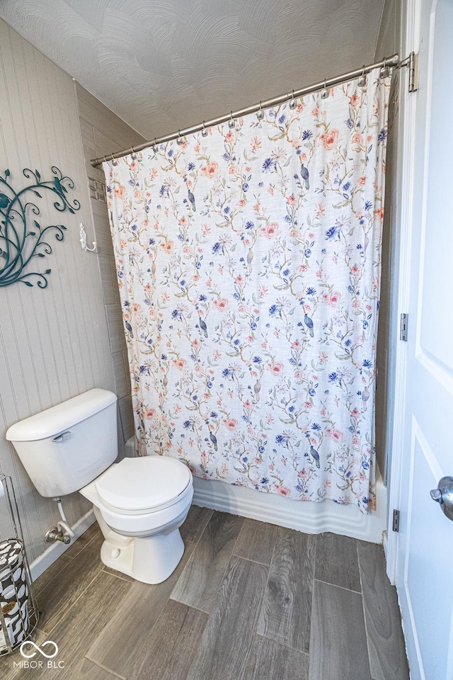 bathroom featuring shower / bath combo, hardwood / wood-style floors, and toilet