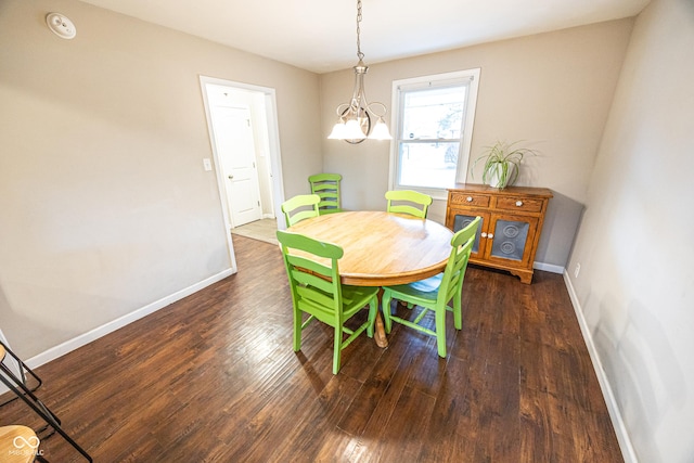 dining area with dark hardwood / wood-style flooring and a chandelier