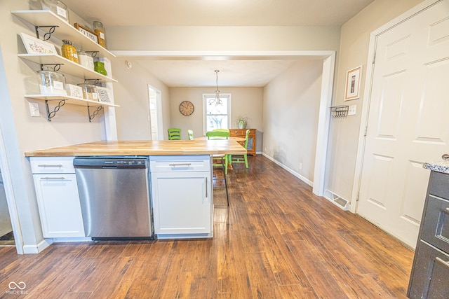 kitchen featuring hanging light fixtures, white cabinetry, stainless steel dishwasher, and butcher block countertops