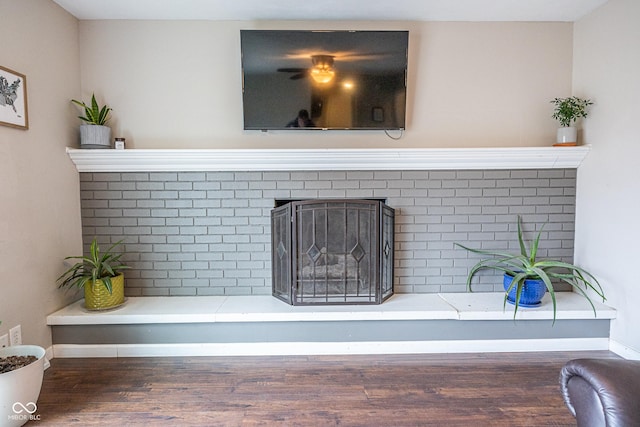 interior details featuring a brick fireplace and hardwood / wood-style floors