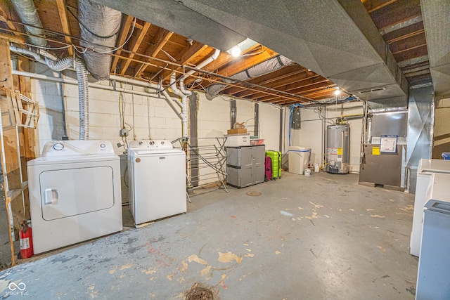 basement with heating unit, washer and dryer, and gas water heater