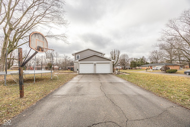 view of home's exterior featuring a garage, a trampoline, and a lawn