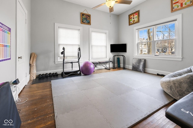 exercise area featuring dark wood-type flooring and ceiling fan