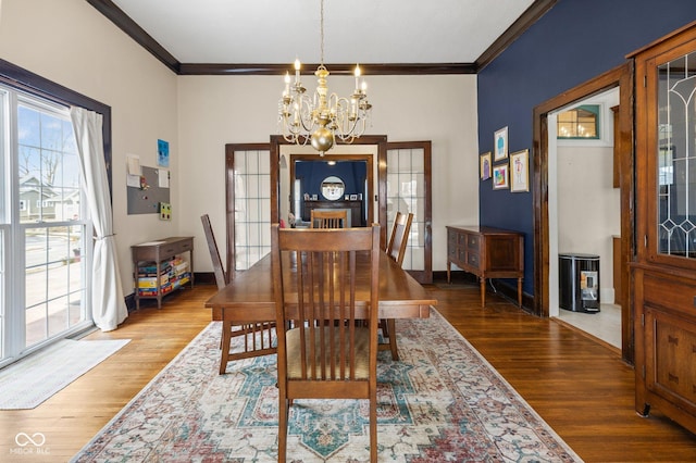 dining room featuring an inviting chandelier, hardwood / wood-style floors, and crown molding