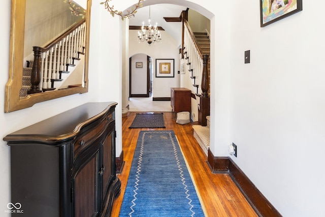 corridor featuring dark wood-type flooring and a chandelier