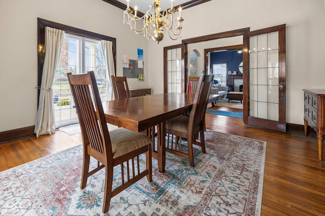 dining space featuring a notable chandelier, dark hardwood / wood-style floors, and french doors