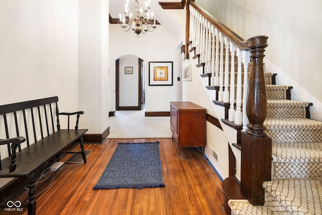 staircase featuring an inviting chandelier and wood-type flooring