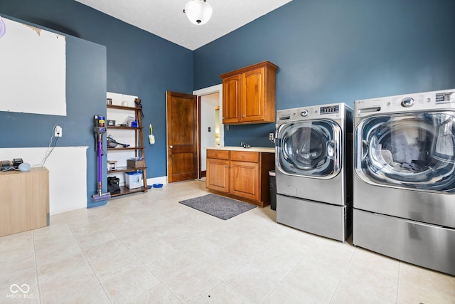 laundry room featuring cabinets, washing machine and dryer, sink, and light tile patterned floors