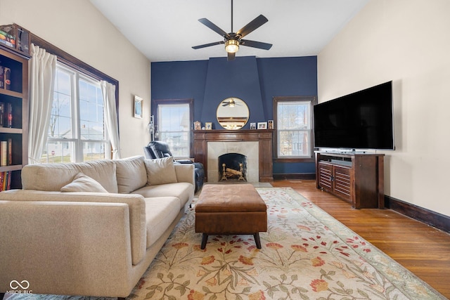 living room featuring hardwood / wood-style flooring, a tile fireplace, a wealth of natural light, and ceiling fan