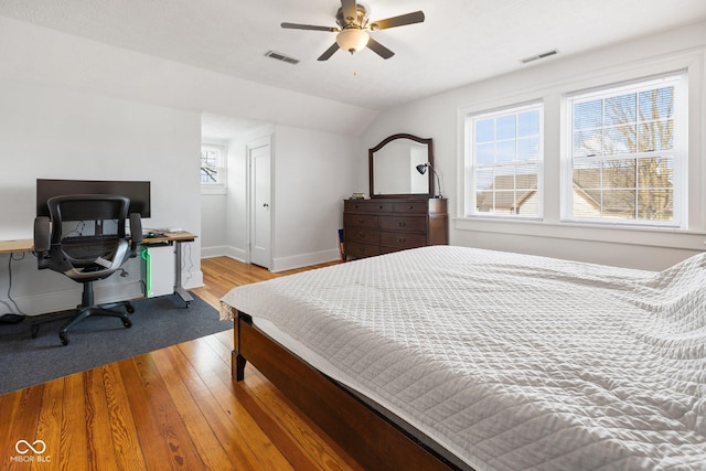 bedroom with multiple windows, vaulted ceiling, light hardwood / wood-style floors, and ceiling fan