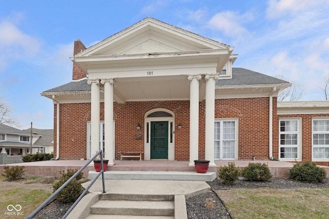 greek revival inspired property featuring a porch