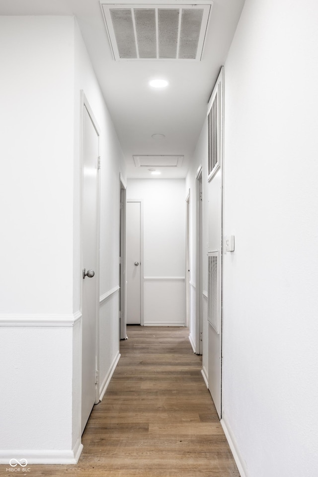 hallway with hardwood / wood-style floors