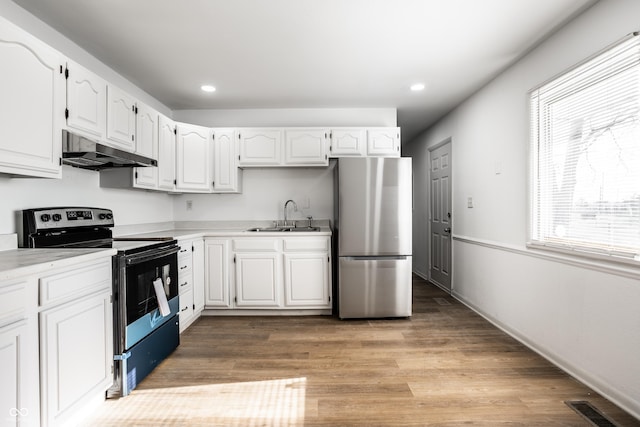 kitchen with white cabinetry, electric range, and stainless steel refrigerator