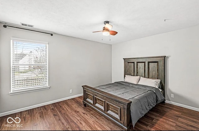 bedroom featuring ceiling fan, dark hardwood / wood-style flooring, and a textured ceiling