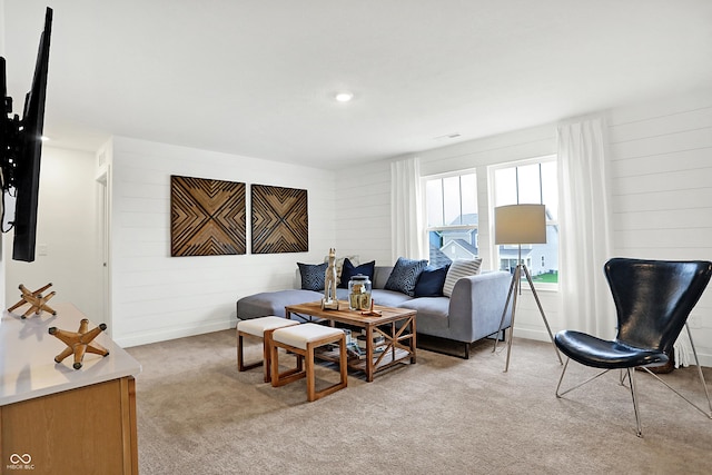 living room featuring light colored carpet and wood walls