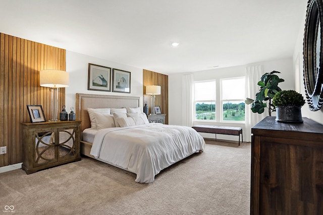 bedroom with wooden walls and light colored carpet