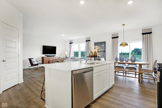 kitchen featuring white cabinetry, dishwasher, pendant lighting, and an island with sink