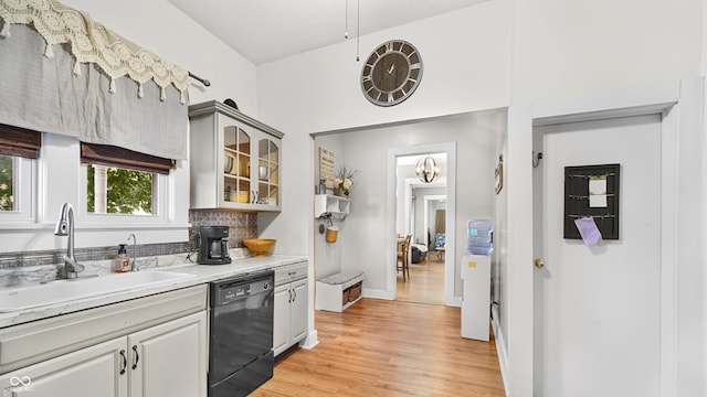 kitchen with sink, tasteful backsplash, light hardwood / wood-style flooring, gray cabinets, and dishwasher