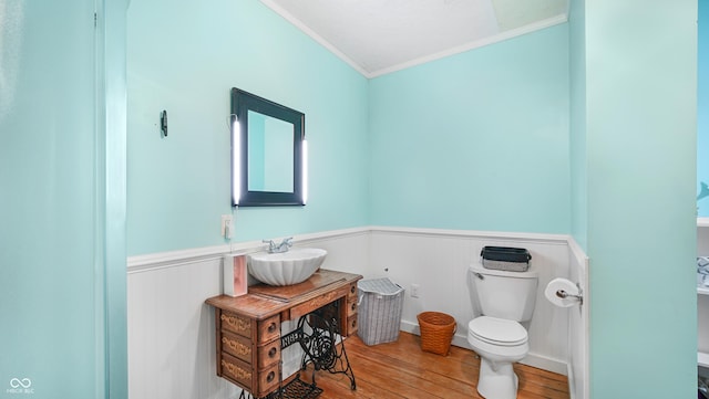 bathroom with sink, hardwood / wood-style flooring, ornamental molding, and toilet