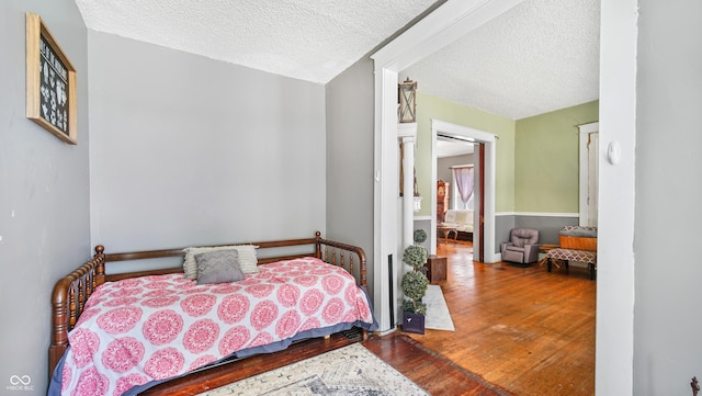 bedroom with hardwood / wood-style flooring and a textured ceiling