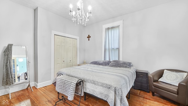 bedroom featuring hardwood / wood-style flooring, a closet, and a notable chandelier