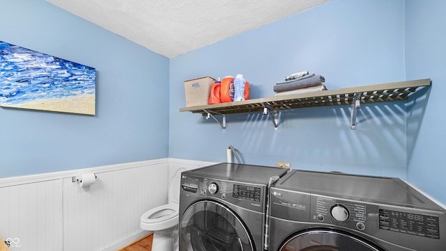 laundry area featuring hardwood / wood-style floors, a textured ceiling, and washer and clothes dryer