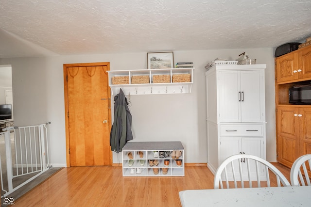 mudroom with light hardwood / wood-style floors and a textured ceiling